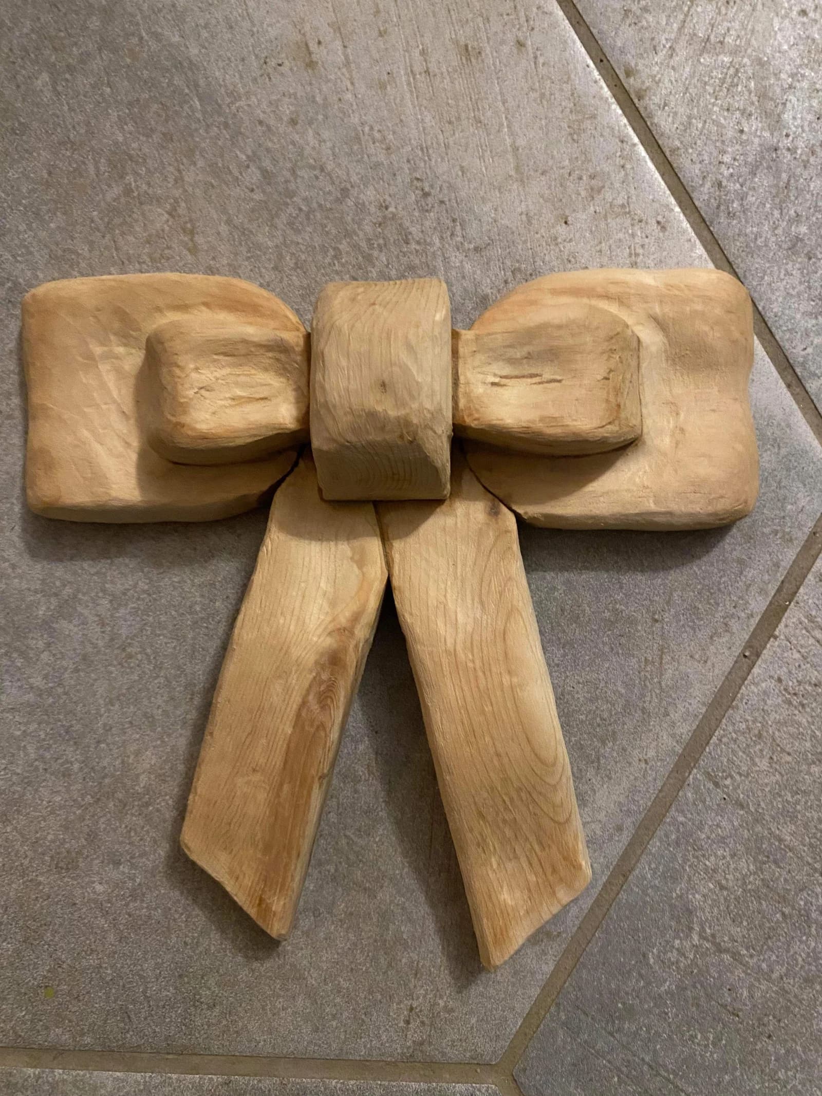 Hand-carved wooden bow resting on a tiled floor